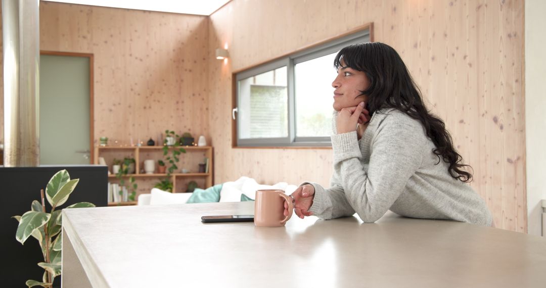 Woman Reflecting by Cozy Counter with Ceramic Mug in Modern Space