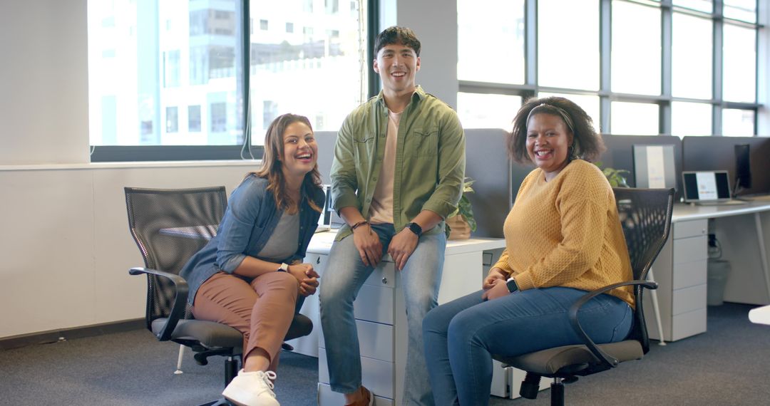 Smiling diverse team collaborating in bright modern open-plan office