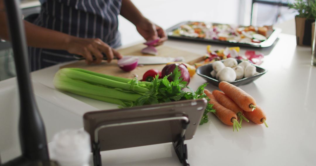 Person Chopping Vegetables in Modern Kitchen with Tablet - Free Images, Stock Photos and Pictures on Pikwizard.com