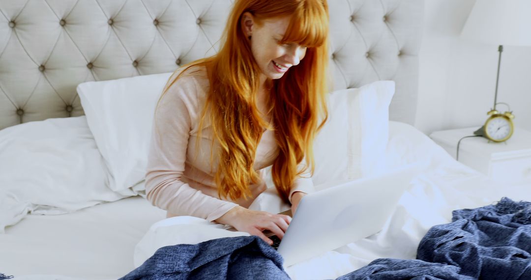 Smiling Redhead Woman Using Laptop on Bed in Cozy Bright Room - Free Images, Stock Photos and Pictures on Pikwizard.com