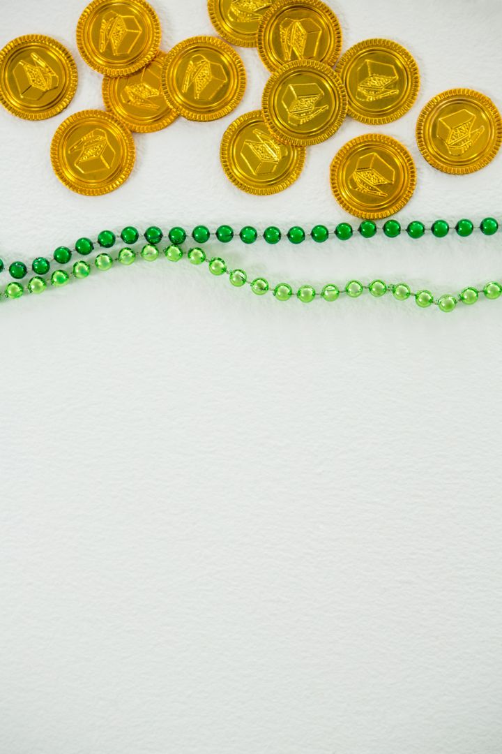 St Patricks Day gold chocolate coin and beads - Free Images, Stock Photos and Pictures on Pikwizard.com