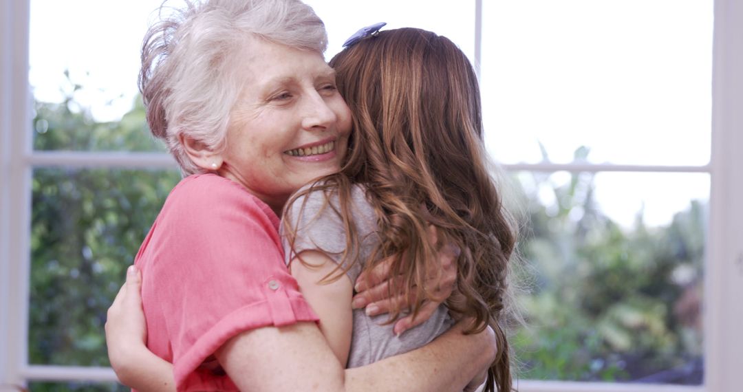 Happy Grandmother Hugging Granddaughter in Bright Living Room - Free Images, Stock Photos and Pictures on Pikwizard.com