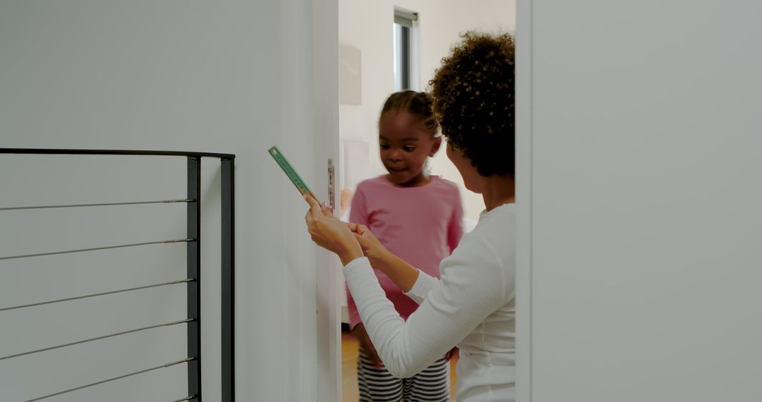 Mother and Daughter Measuring Growth Together at Home