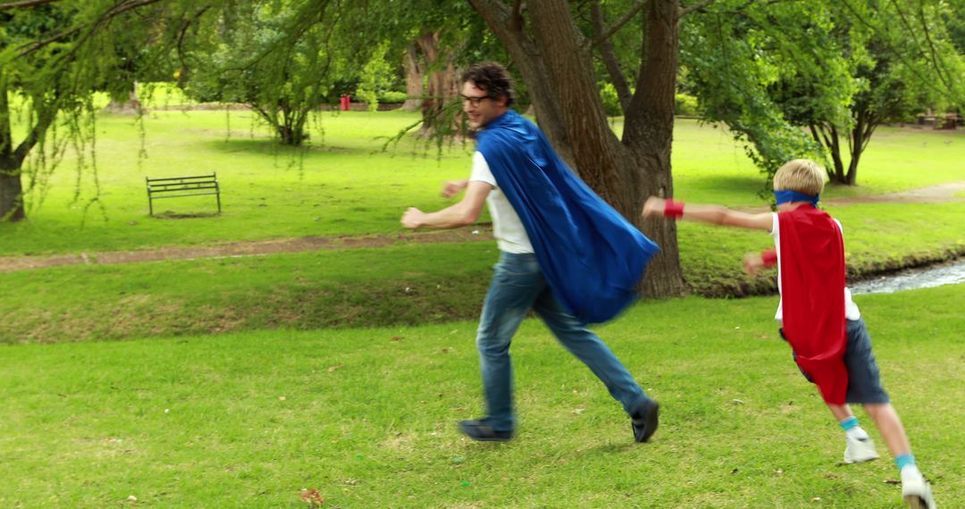 Father and son running in superhero capes in park - Free Images, Stock Photos and Pictures on Pikwizard.com