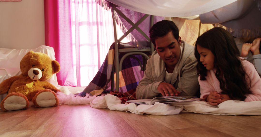 Father and Daughter Reading Together in Blanket Fort - Free Images, Stock Photos and Pictures on Pikwizard.com