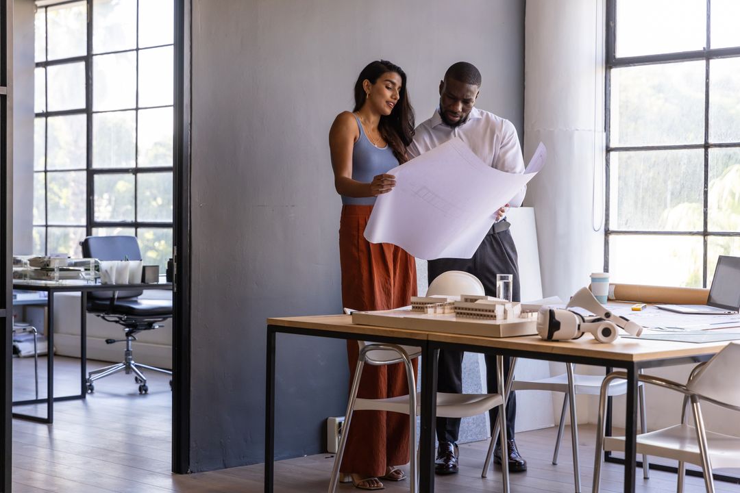 Diverse Design Studio Team Analyzing Architectural Blueprint Together