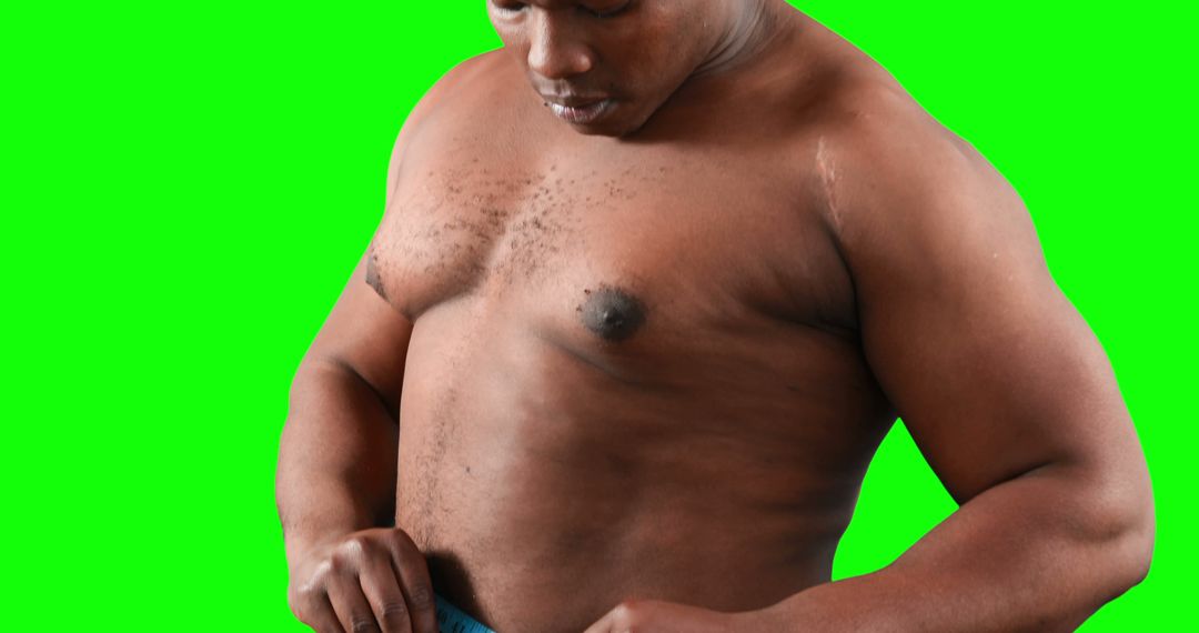 Muscular Black Man Dressing Against Green Background - Free Images, Stock Photos and Pictures on Pikwizard.com