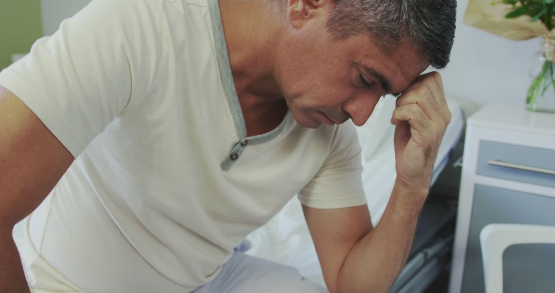 Worried Middle-Aged Man Sitting in Bedroom - Free Images, Stock Photos and Pictures on Pikwizard.com