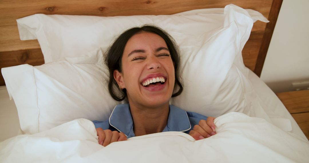 Joyful Woman in Pajamas Relaxing on Comfortable Bed