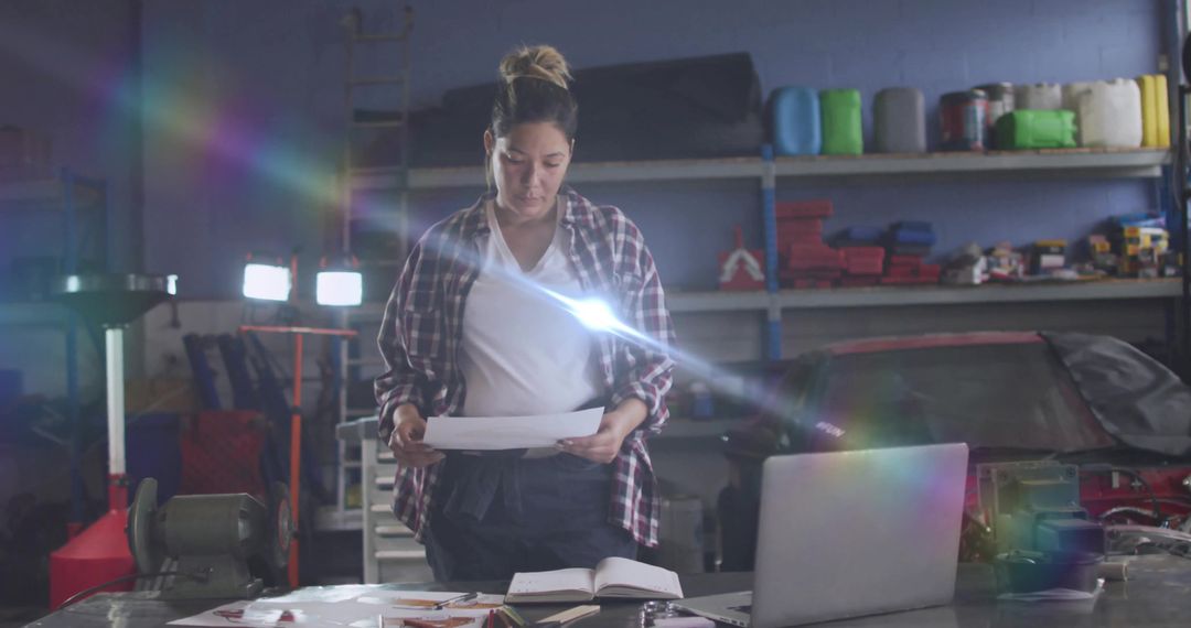 Female Mechanic Analyzing Plans in Automotive Workshop