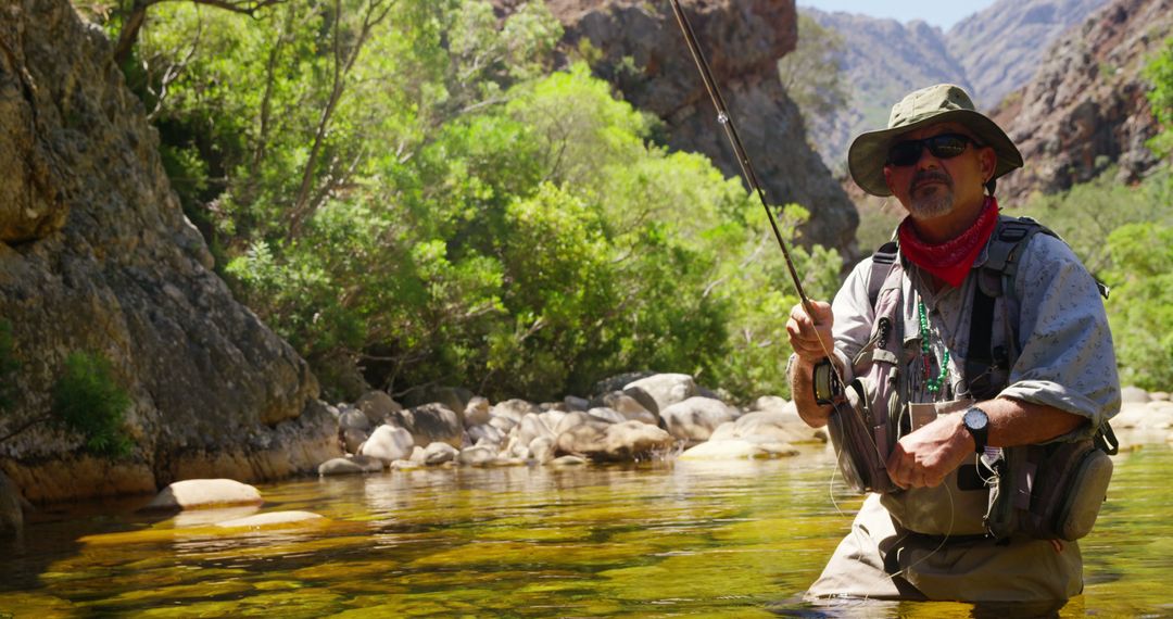 Man Fly Fishing in Rocky Mountain Stream Surrounded by Lush Vegetation - Free Images, Stock Photos and Pictures on Pikwizard.com