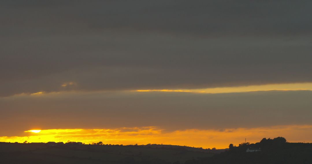 Serene Sunset Over Rolling Hills with Dramatic Clouds - Free Images, Stock Photos and Pictures on Pikwizard.com