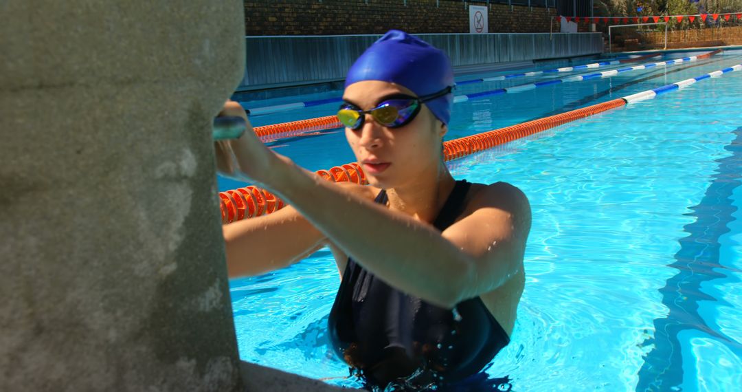 Female Swimmer Preparing for Exercise in Outdoor Pool - Free Images, Stock Photos and Pictures on Pikwizard.com