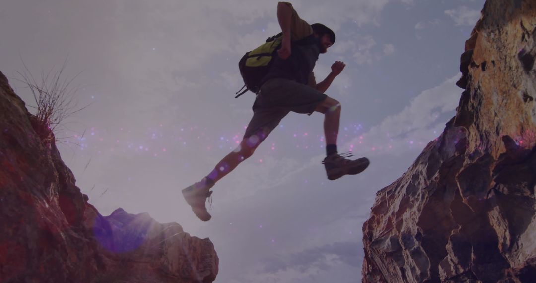 Adventurous Hiker Leaping Across Canyon Gap in Wilderness