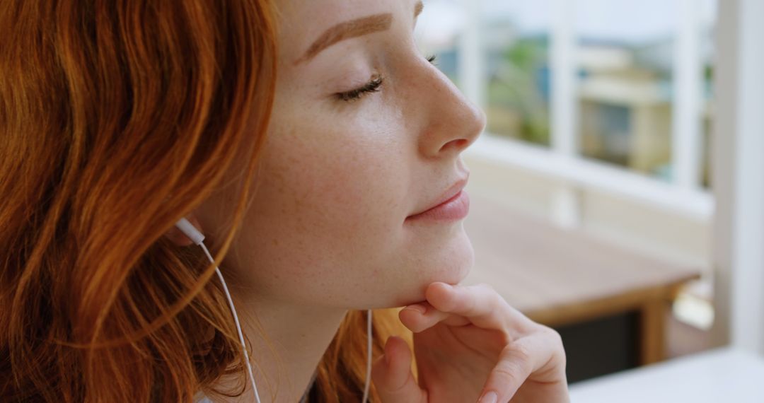 Young Woman with Red Hair Enjoying Music with Earbuds - Free Images, Stock Photos and Pictures on Pikwizard.com