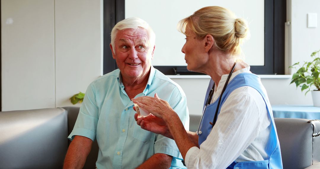 Elderly Man and Nurse Interacting in Healthcare Setting - Free Images, Stock Photos and Pictures on Pikwizard.com