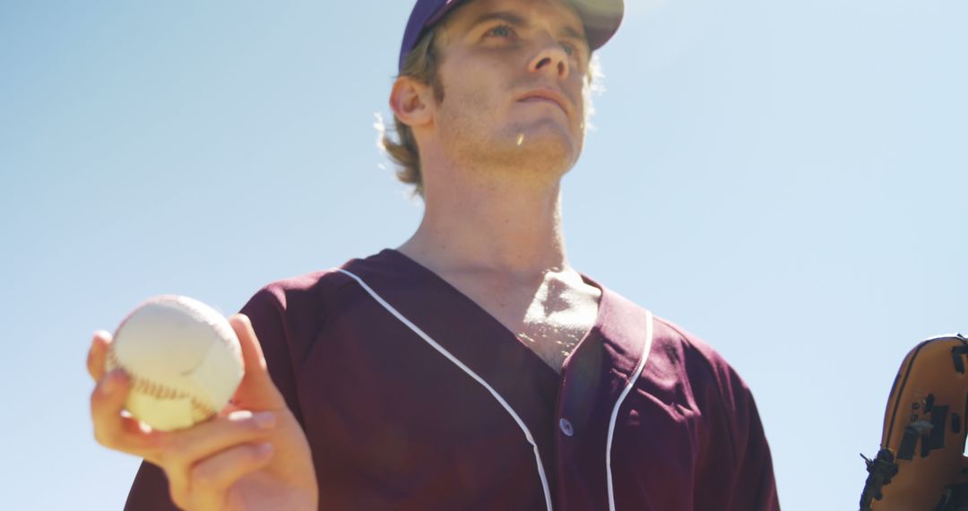 Baseball Player Holding Ball with Glove Under Clear Sky - Free Images, Stock Photos and Pictures on Pikwizard.com