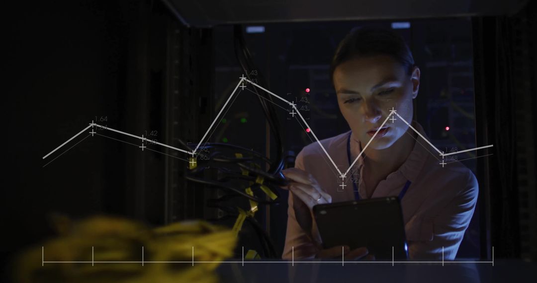 Female Technician Analyzing Data in Dark Server Room