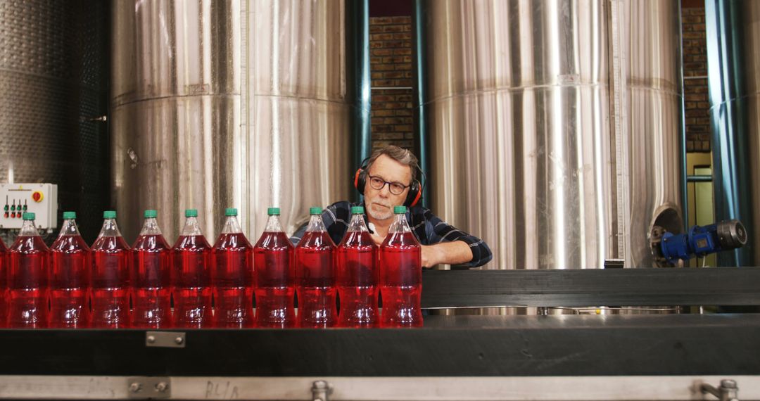 Factory Worker Supervising Soda Bottles on Production Line - Free Images, Stock Photos and Pictures on Pikwizard.com