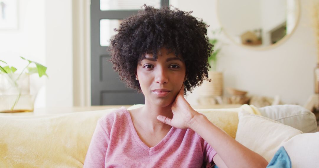 Thoughtful Young African American Woman Sitting on Sofa - Free Images, Stock Photos and Pictures on Pikwizard.com