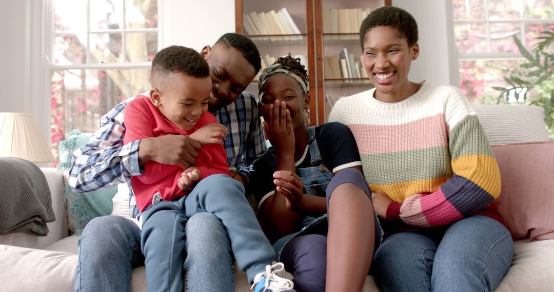 Happy African American Family Laughing Together on Couch at Home - Free Images, Stock Photos and Pictures on Pikwizard.com