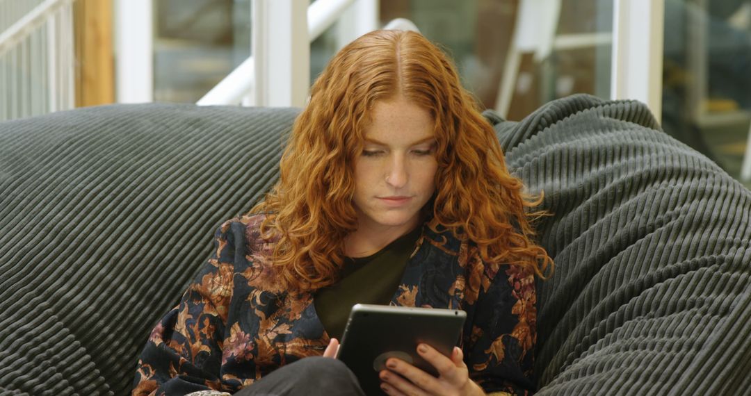 Young Woman with Red Hair Relaxing on Couch Using Tablet - Free Images, Stock Photos and Pictures on Pikwizard.com