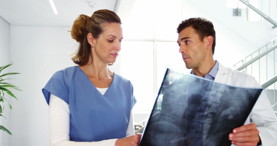 Healthcare Professionals Reviewing X-Ray in Modern Hospital - Free Images, Stock Photos and Pictures on Pikwizard.com