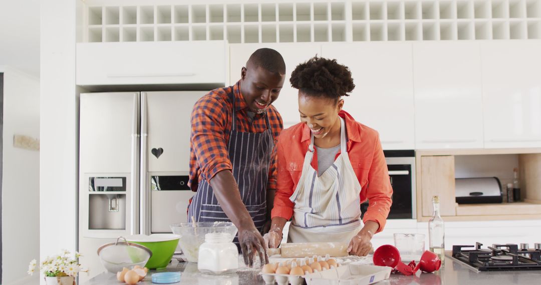 Image of happy african american couple baking together and having fun with flour - Free Images, Stock Photos and Pictures on Pikwizard.com