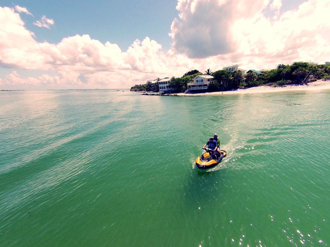 Person riding jet ski near tropical beach - Free Images, Stock Photos and Pictures on Pikwizard.com