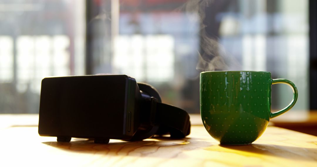 Virtual Reality Headset and Steaming Coffee Cup on Table in Sunlit Room - Free Images, Stock Photos and Pictures on Pikwizard.com