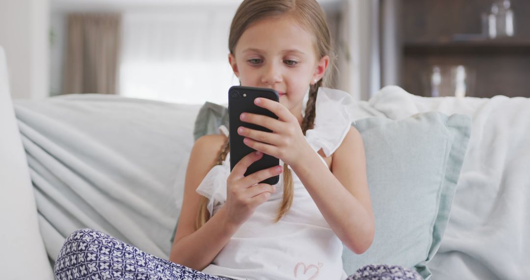 Young Girl Sitting on Couch Using Smartphone at Home - Free Images, Stock Photos and Pictures on Pikwizard.com