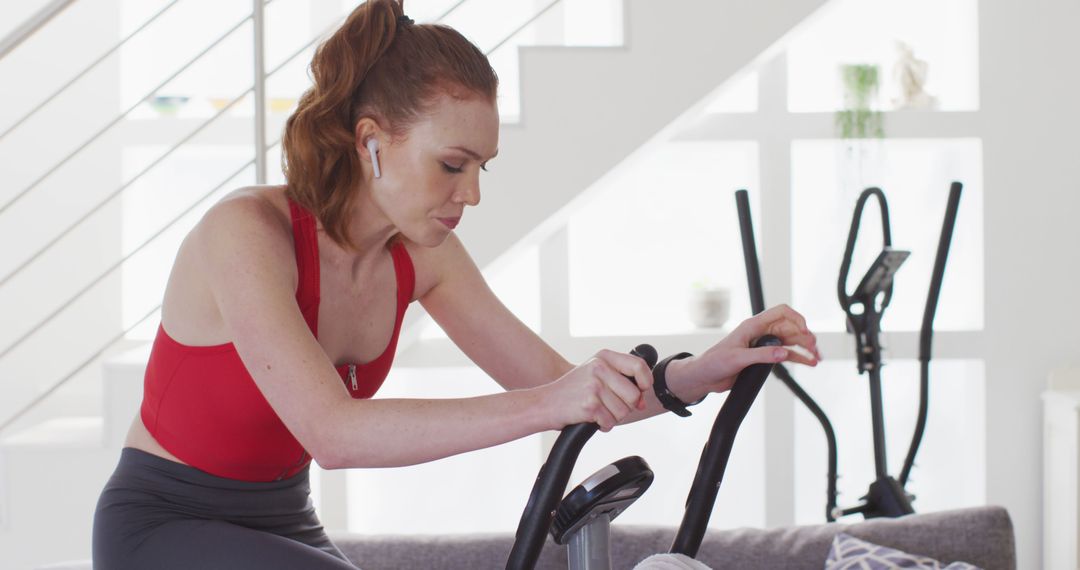 Young Woman Exercising at Home on Stationary Bike - Free Images, Stock Photos and Pictures on Pikwizard.com