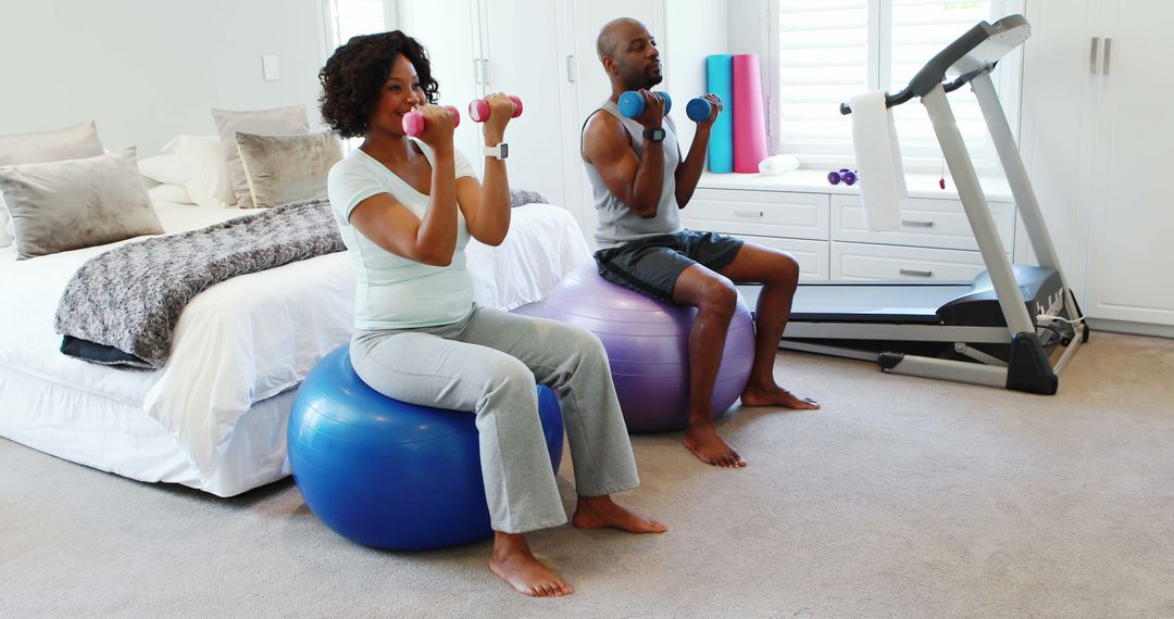 Couple Exercising at Home with Dumbbells and Fitness Balls