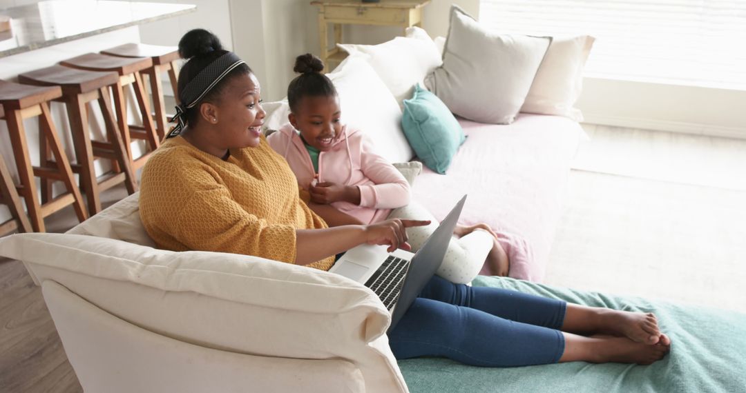 Happy African American Mother and Daughter Using Laptop on Couch - Free Images, Stock Photos and Pictures on Pikwizard.com