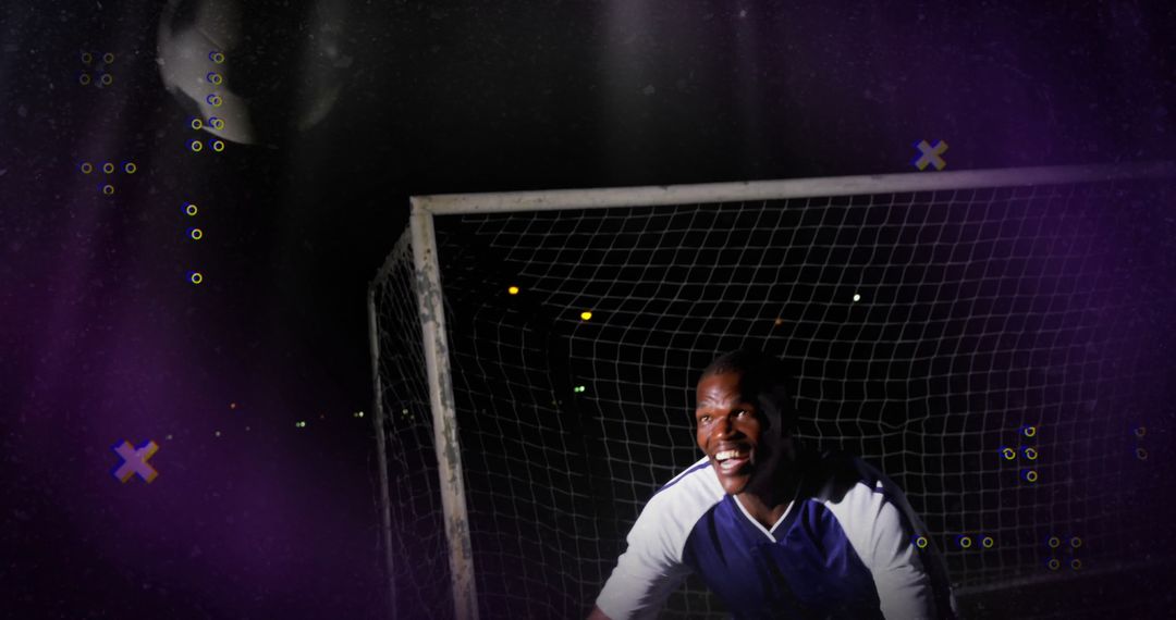 Crouching Goalkeeper Ready for Action in Night Soccer Field
