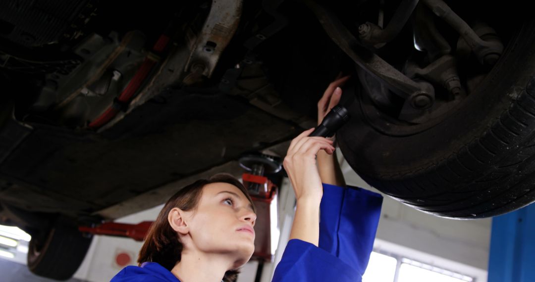 Female Auto Mechanic Inspecting Car Undercarriage in Workshop - Free Images, Stock Photos and Pictures on Pikwizard.com