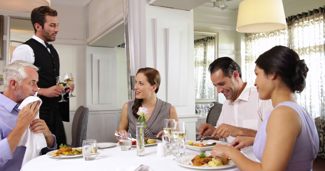 Group of people dining in gourmet restaurant, being served by waiter - Free Images, Stock Photos and Pictures on Pikwizard.com