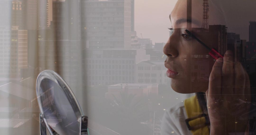 Young woman applying mascara with city skyline reflection in mirror close-up at dusk