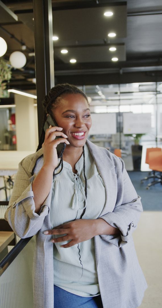 Smiling African American Businesswoman Talking on Mobile Phone in Office - Free Images, Stock Photos and Pictures on Pikwizard.com