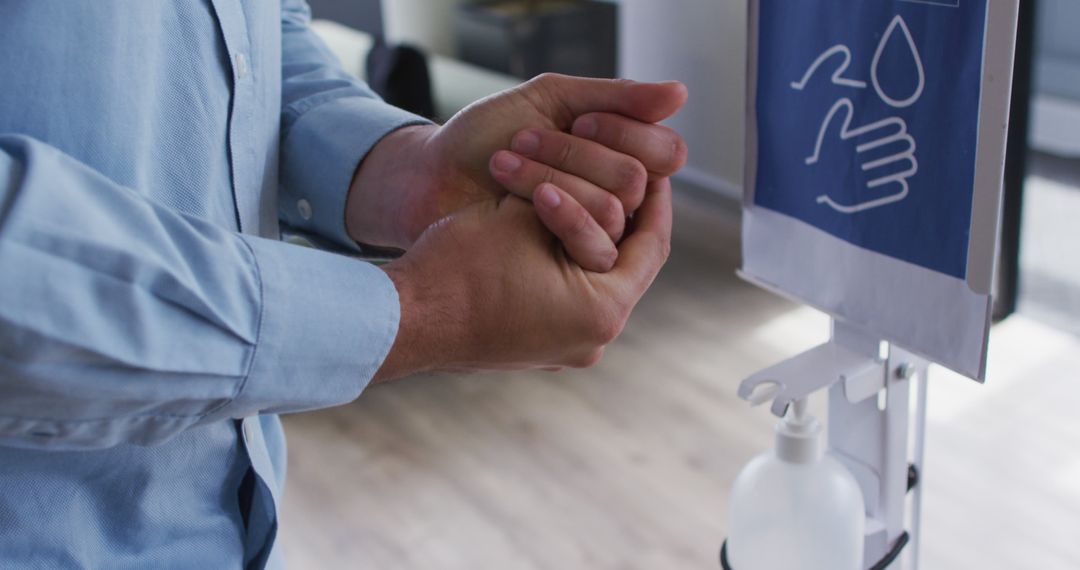 Person Using Hand Sanitizer Dispenser in Office - Free Images, Stock Photos and Pictures on Pikwizard.com