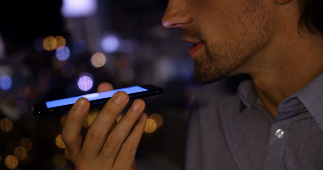 Young Professional Using Voice Command on Smartphone in Office at Night