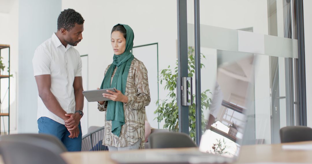 Diverse Coworkers Collaborating on Tablet in Modern Office Space