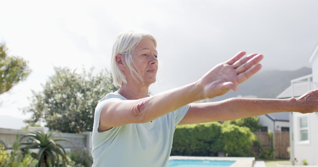 Senior Woman Stretching in Backyard Next to Swimming Pool - Free Images, Stock Photos and Pictures on Pikwizard.com