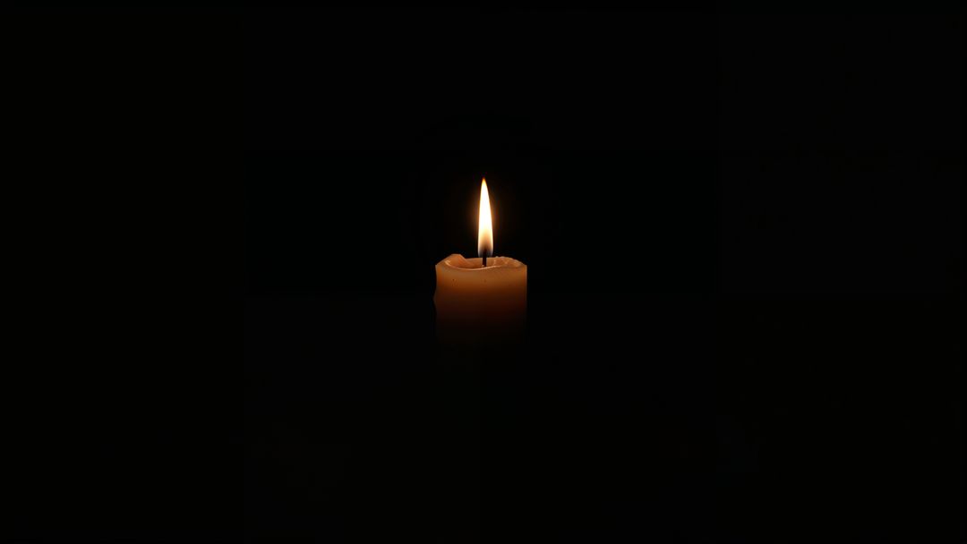 Solitary Candle Illuminating Dark Room with Warm Glow