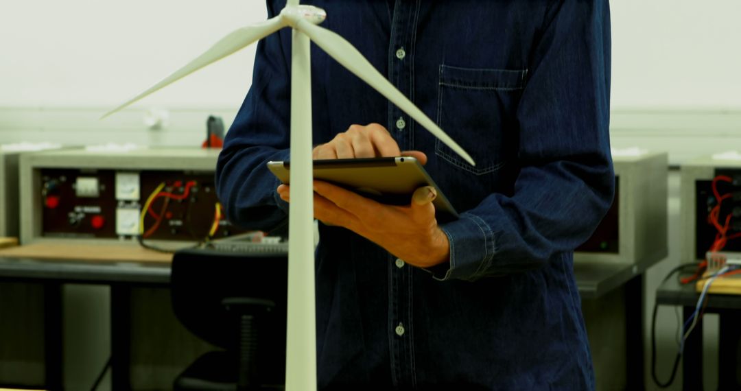 Engineer Analyzing Wind Turbine Model with Tablet in Laboratory - Free Images, Stock Photos and Pictures on Pikwizard.com