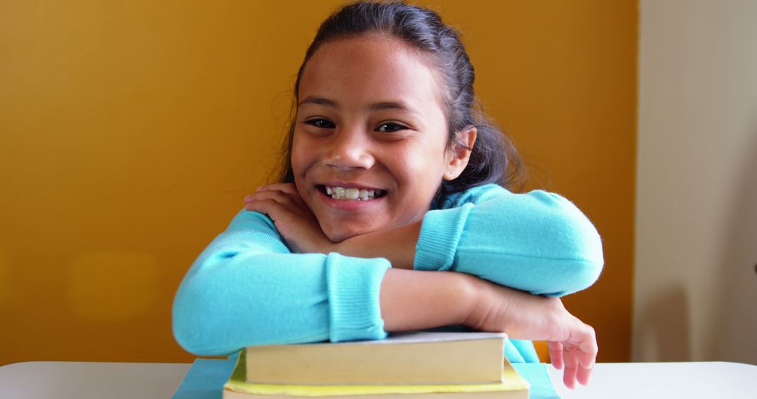 Smiling Girl Leaning on Stack of Books - Free Images, Stock Photos and Pictures on Pikwizard.com