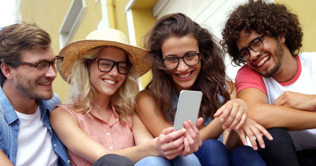 Group of Friends Smiling and Looking at Smartphone Outdoors - Free Images, Stock Photos and Pictures on Pikwizard.com