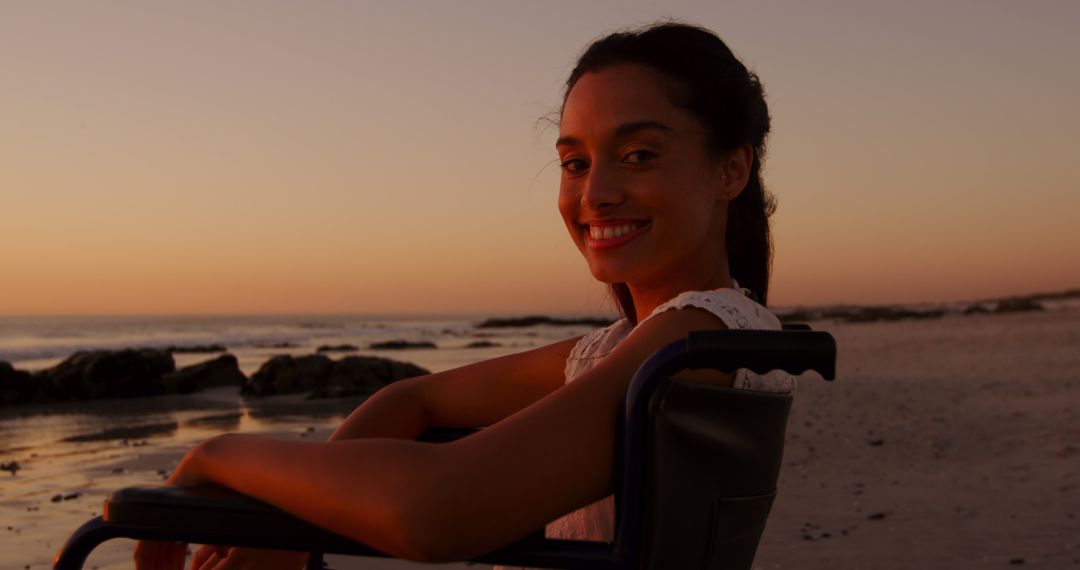 Smiling Woman in Wheelchair Enjoying Sunset at Beach - Free Images, Stock Photos and Pictures on Pikwizard.com