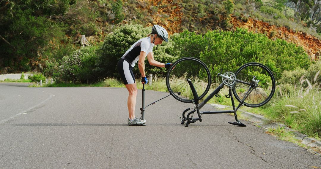 Cyclist Fixing Flat Tire on Rural Road - Free Images, Stock Photos and Pictures on Pikwizard.com