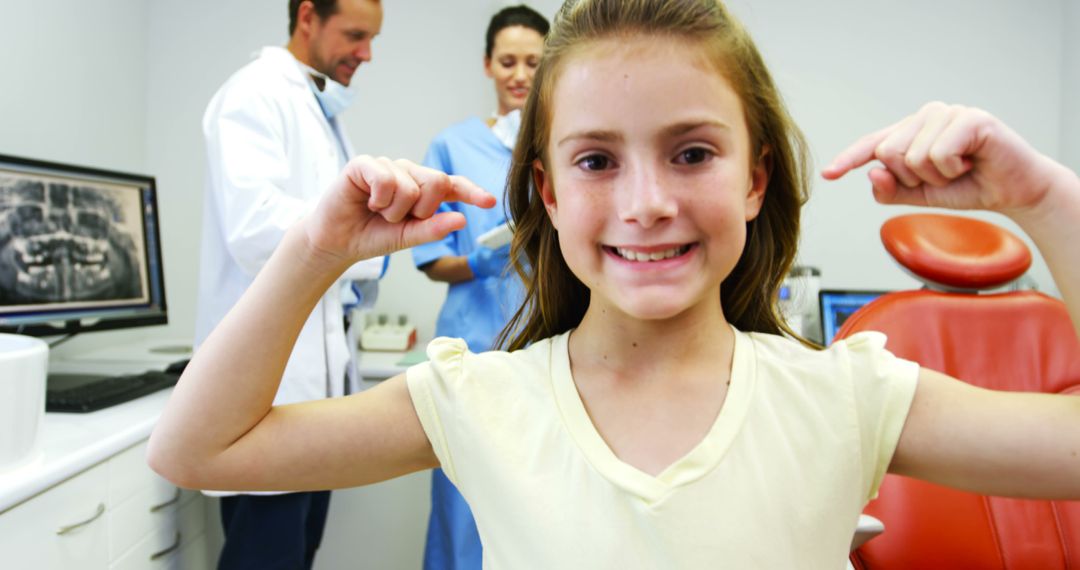 Smiling Girl at Dental Clinic with Dental Team in Background - Free Images, Stock Photos and Pictures on Pikwizard.com